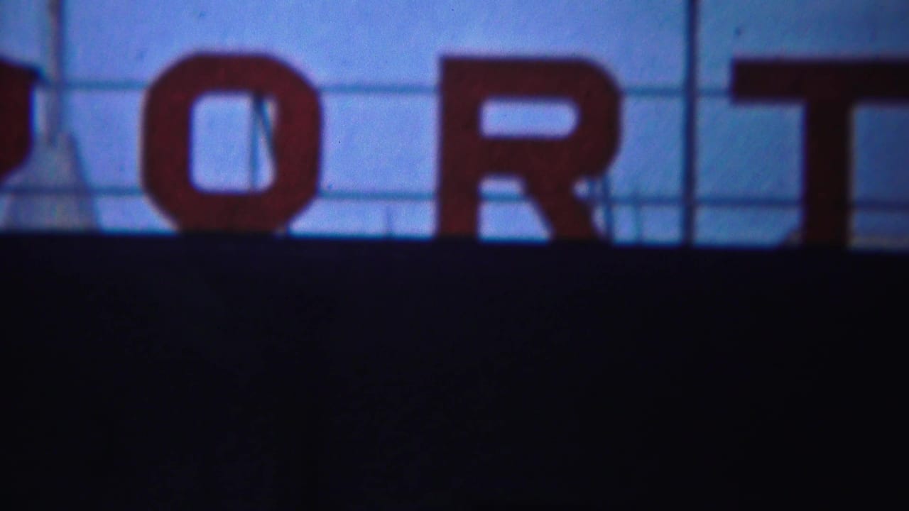Large red letters spelling part of PORT against blue sky above a dark foreground.