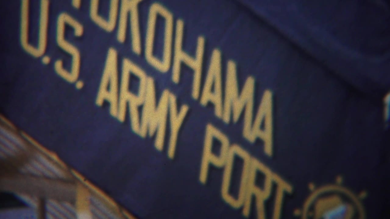 Dark blue sign with gold lettering reading Yokohama U.S. Army Port at an angle.