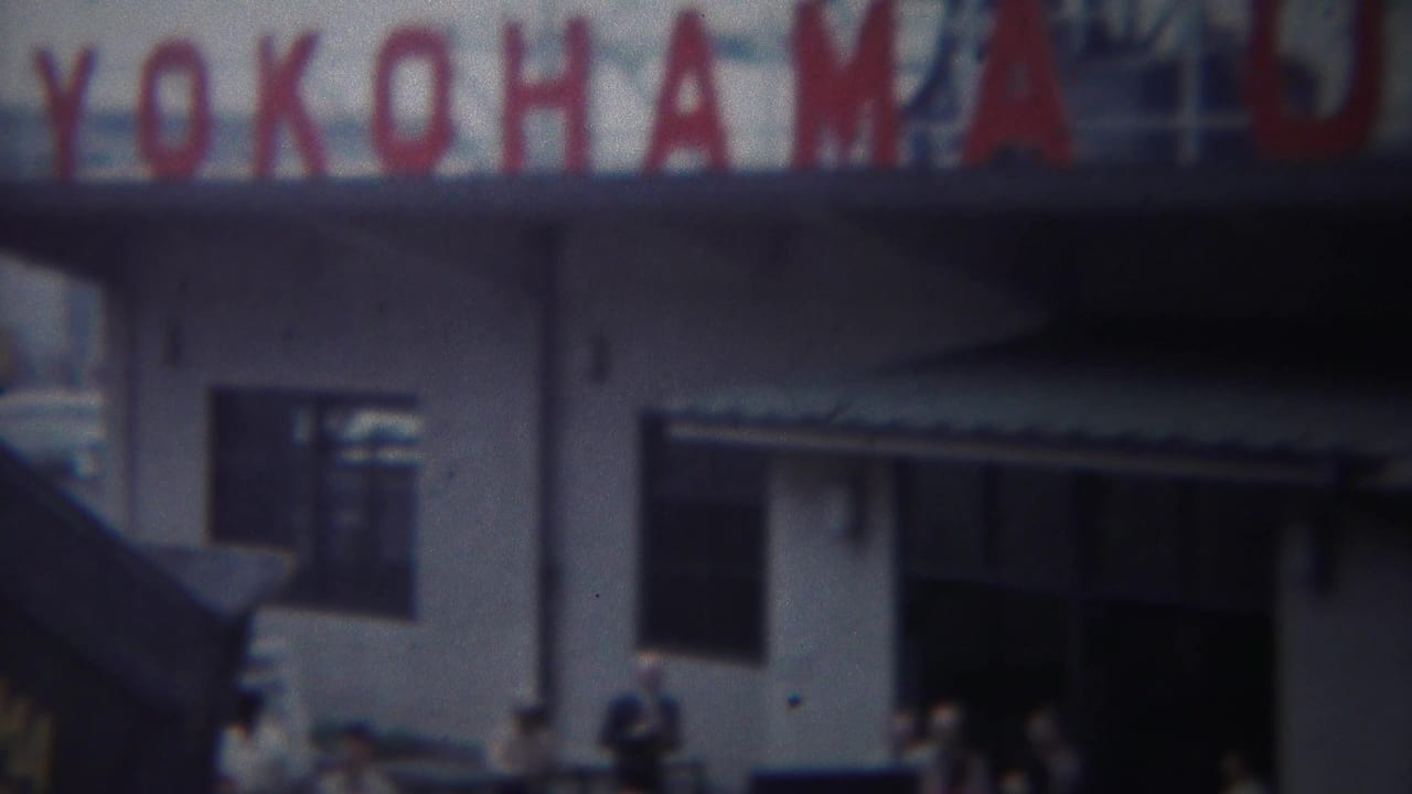 Large red YOKOHAMA U.S. ARMY sign above a white building entrance with people below.