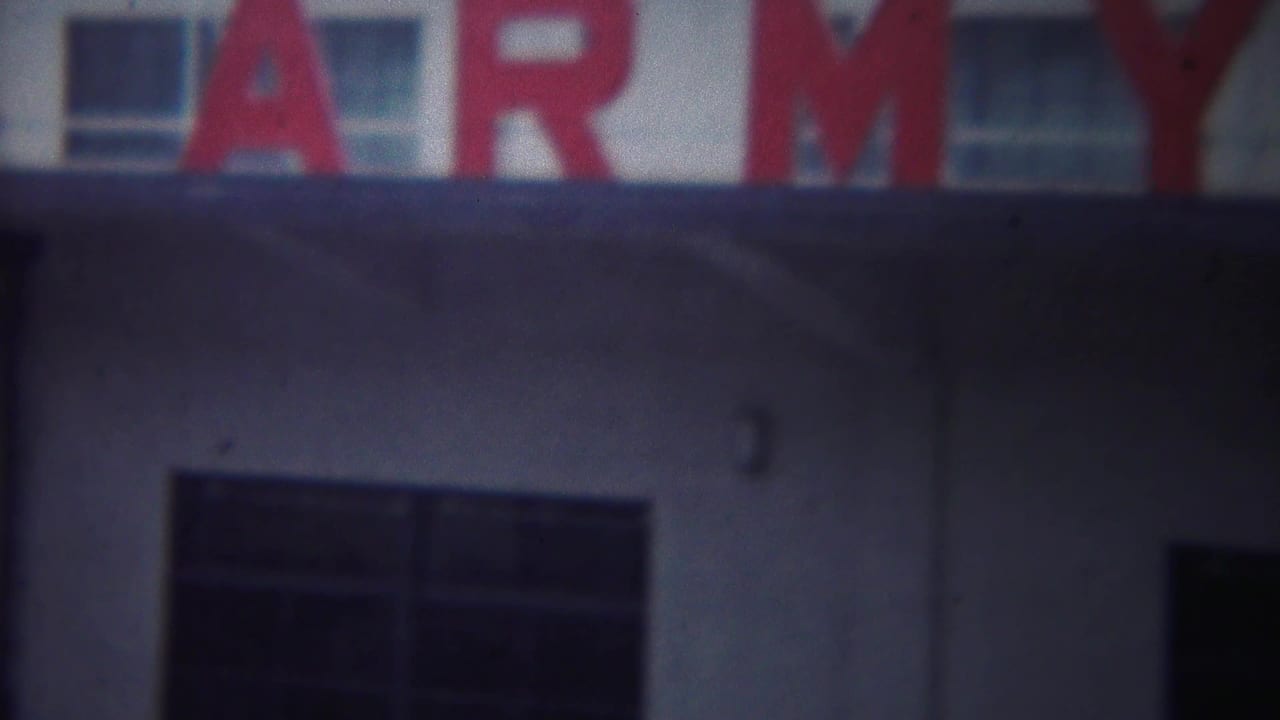Large red Army letters on a pale building above dark windows.
