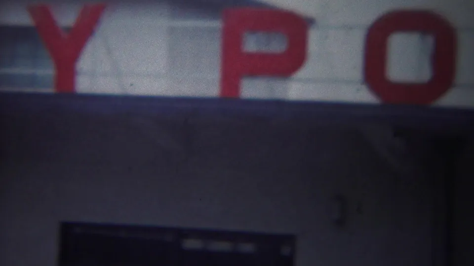 1954 Yokohama frame showing the word Port in red letters across a pale military port building sign.