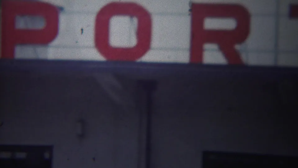 Final 1954 Yokohama frame with red Army Port lettering cropped over a shadowed building facade.