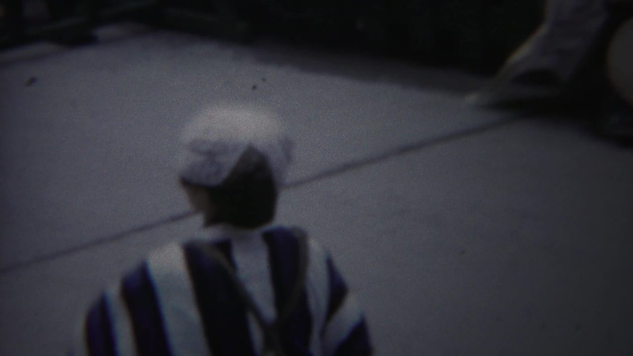The performer turns away from the camera in 1954 Yokohama footage, showing the back of her striped kimono and white head covering.