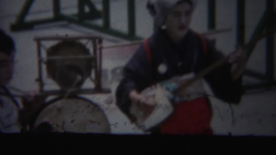 Soft 8mm frame from Yokohama in 1954 showing a traditional music performer beside a large drum.