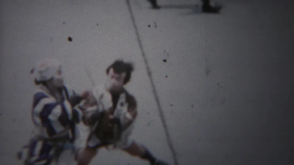 High-angle 1954 Yokohama home-movie view of two costumed performers with traditional instruments on pavement.
