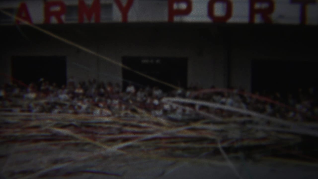 Crowd outside an Army Port building behind windblown streamers.