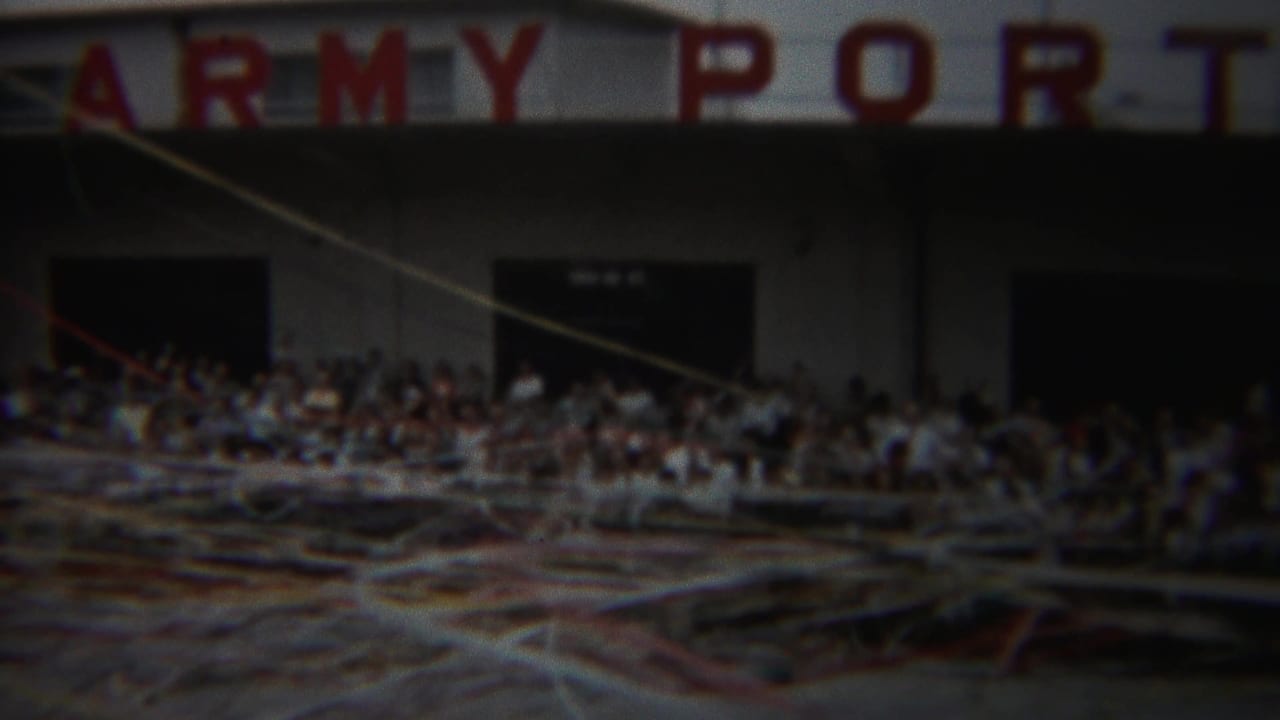 1954 Yokohama Army Port facade seen through windblown streamers, with spectators gathered near dark doorways.