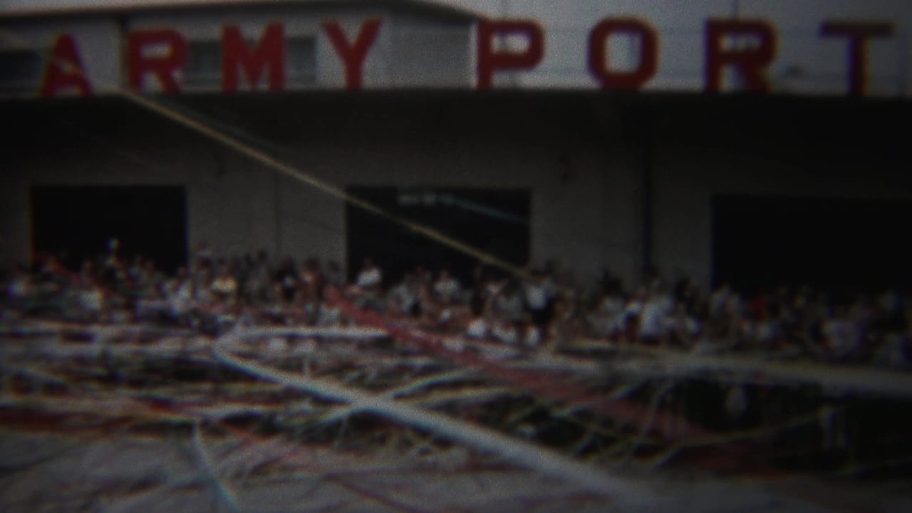 1954 Yokohama crowd scene below ARMY PORT signage, filmed through loose streamers in soft 8mm color.