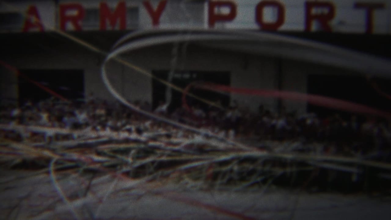 Crowd outside a building marked ARMY PORT with streamers crossing the foreground.