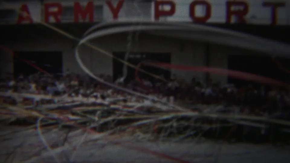 1954 Yokohama home-movie frame showing spectators below an ARMY PORT sign with paper streamers in front.