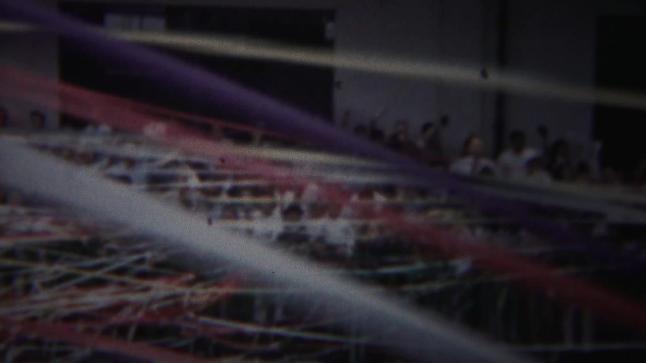 A handheld 1954 Yokohama frame looks through colorful streamers toward people packed along a port balcony.