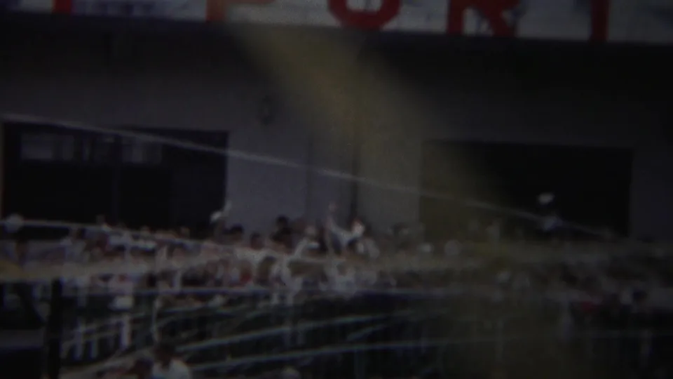 Yokohama 1954 parade or gathering view with spectators at railings in front of a large building with red lettering above.