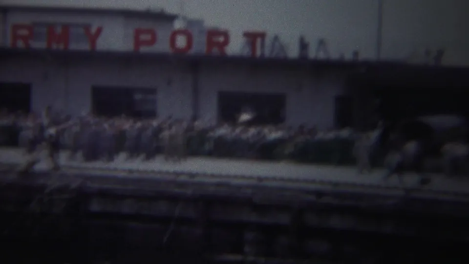 Yokohama, Japan, 1954 frame showing partial ARMY PORT signage, a crowd, parked cars, and foreground brass instruments.