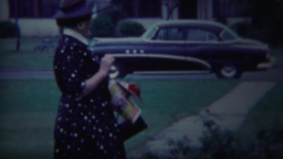 A woman in a polka-dot dress gestures while walking through a South Bend residential neighborhood in 1958.
