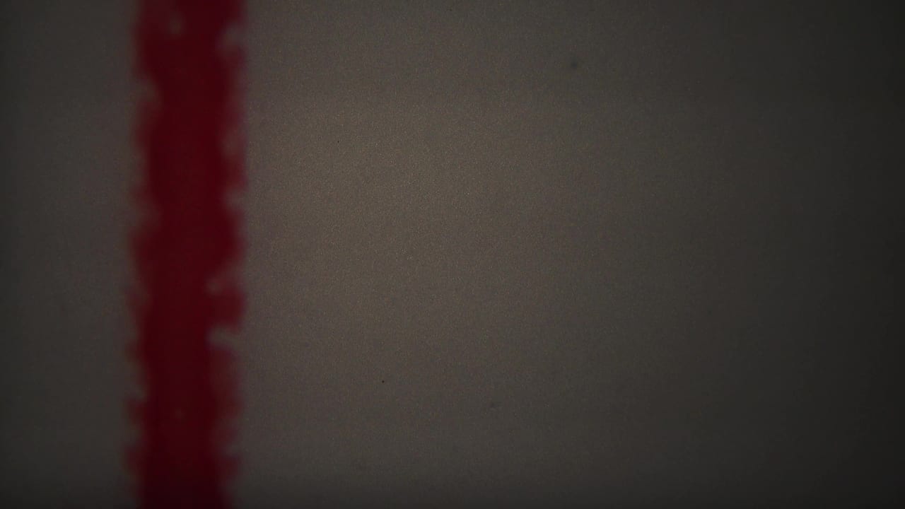 1967 Yellowstone-labeled 8mm frame showing a red vertical zigzag mark against a pale, softly vignetted background.
