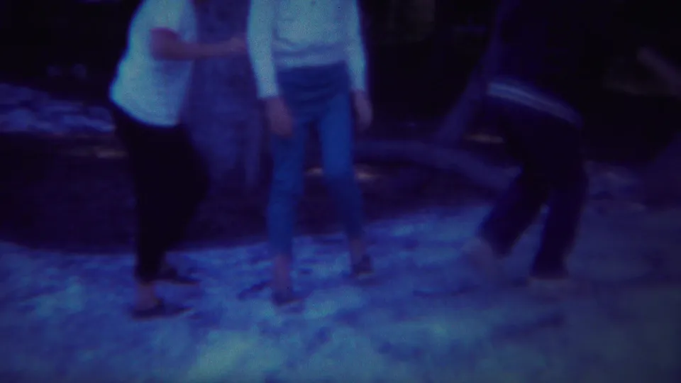 Three people stand in a shaded wooded area at Yellowstone, Wyoming, in blue-tinted 1967 8mm footage.