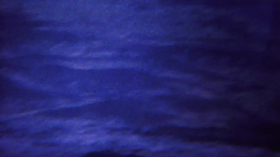 1967 Yellowstone-area 8mm frame of rolling barren ground and distant mountain slopes, with visible grain and exposure variation.