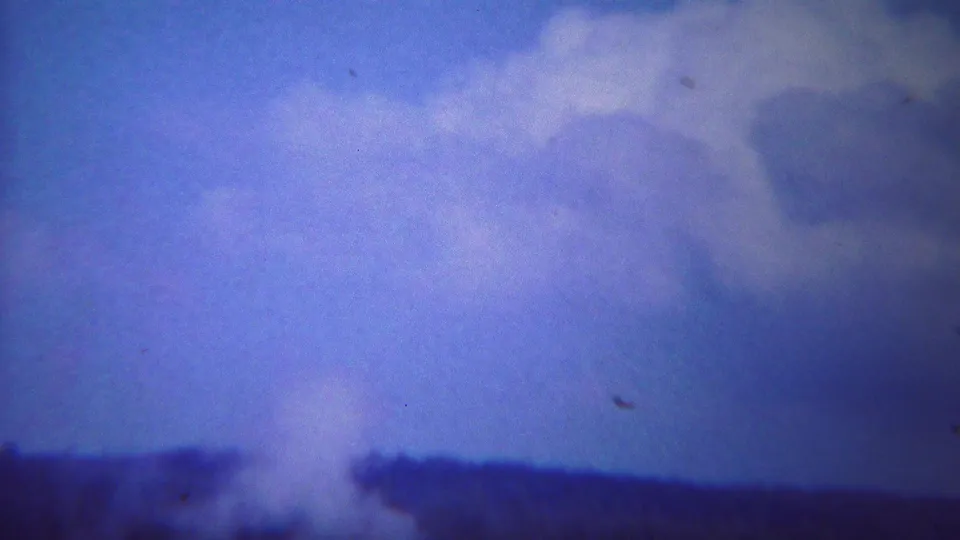 Old Faithful steam rises into a blue-purple sky in this 1967 Yellowstone 8mm home-movie frame.