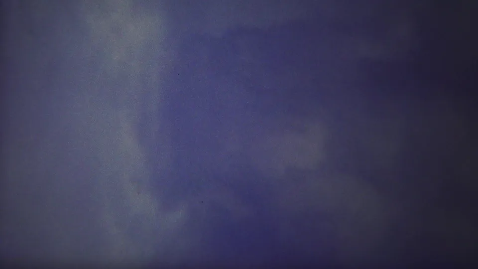 1967 Yellowstone 8mm frame showing misty water below a dark ledge, with grain, scratches, and muted blue tones.