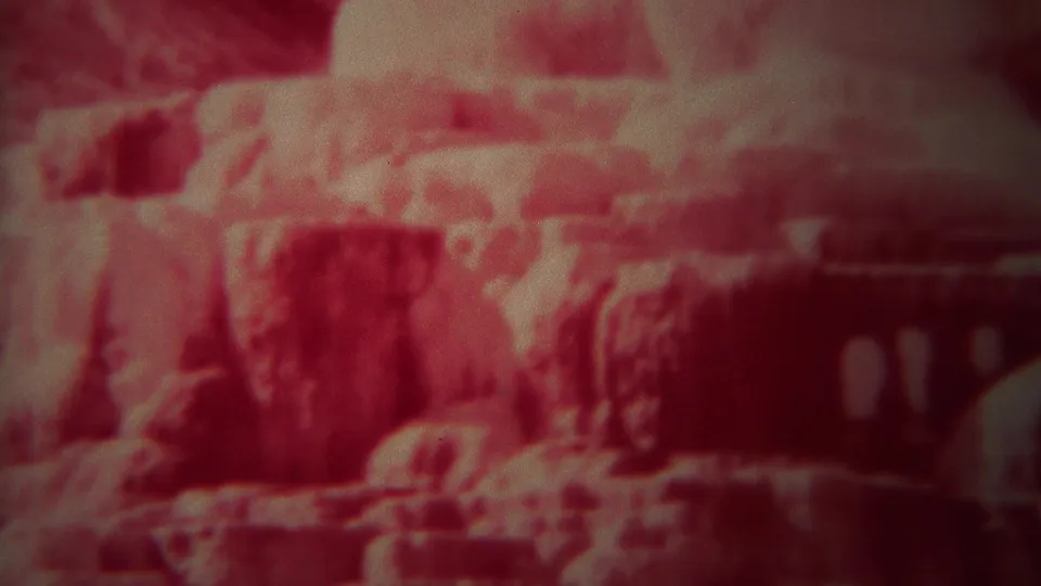 1967 Yellowstone frame showing red-tinted rock or mineral formations with a dark edge along the right side.