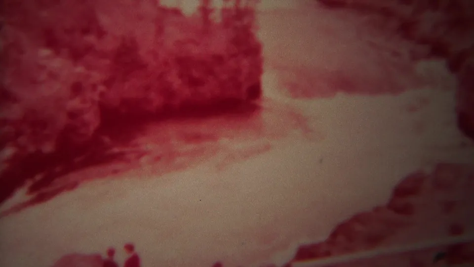 1967 Yellowstone 8mm view of pale river water and red rocky banks, with tiny distant visitors visible near the lower edge.