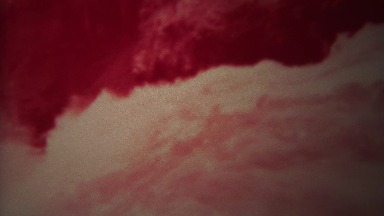 Dark red current above a pale band of foamy moving water.