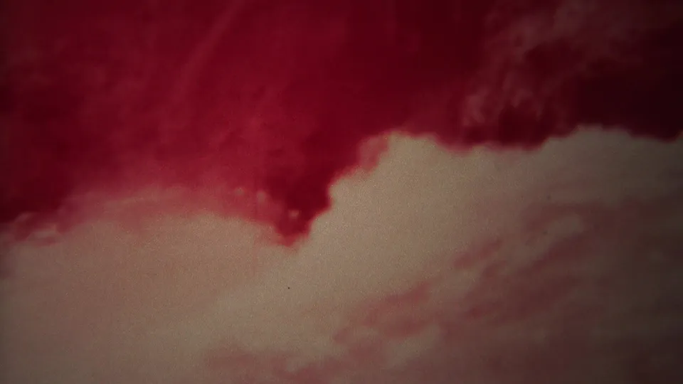 1967 Yellowstone 8mm frame showing a diagonal sweep of pale foam beneath a dark red, swirling water surface.