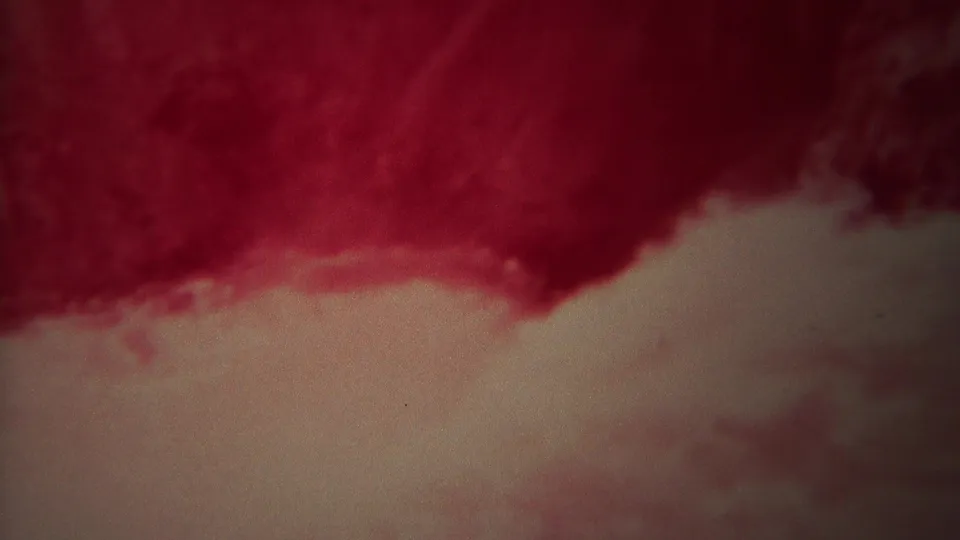 1967 Yellowstone 8mm frame showing red-pink rushing water and a lighter foamy surface, with grain and soft exposure.