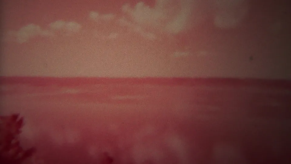 Soft red-tinted Yellowstone lake horizon and sky in 1967 8mm home-movie footage.