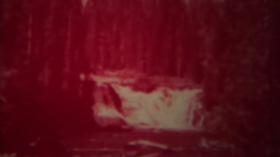 1967 Yellowstone 8mm frame with rushing water set against dense woods, softened by grain and red color shift.