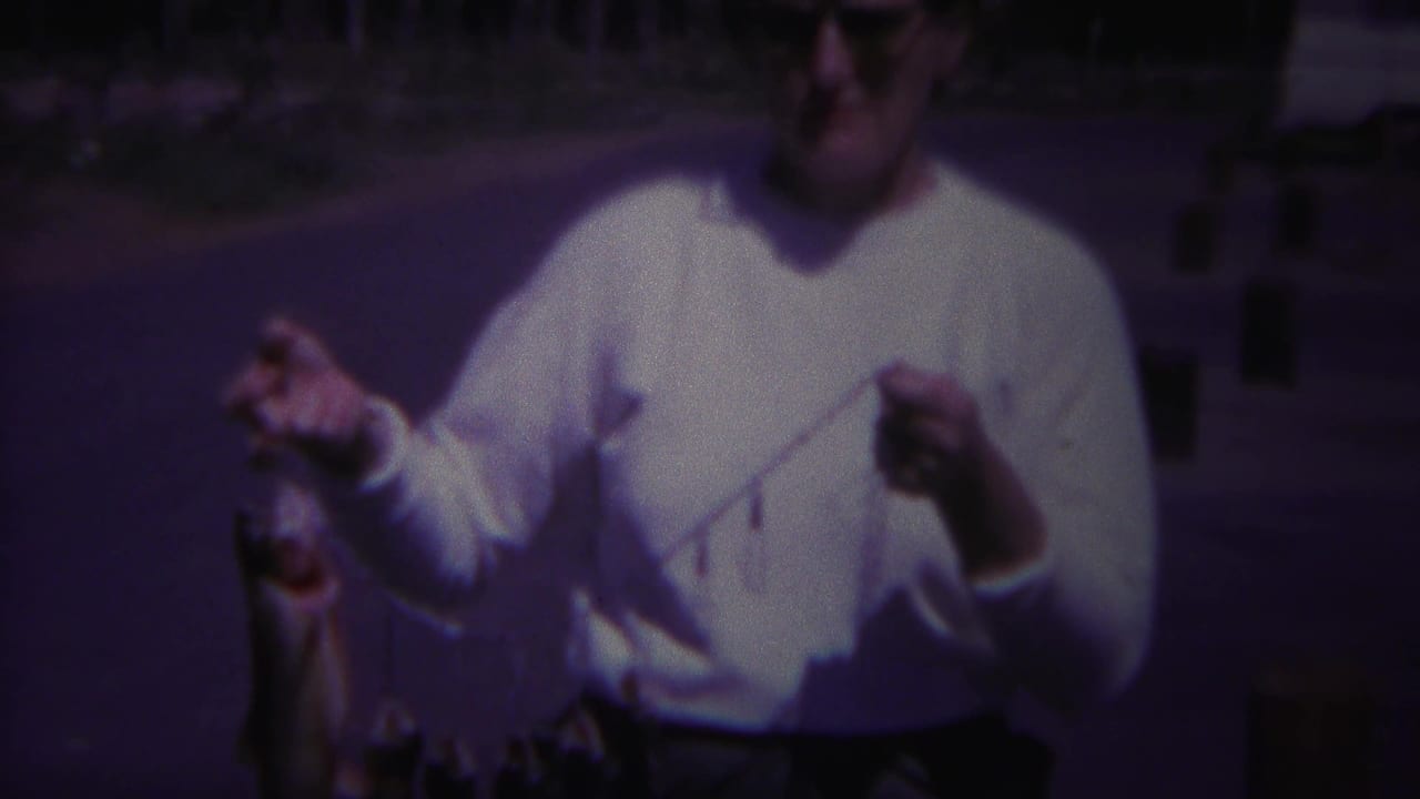 Woman holding a fish stringer with a white camper and trees behind her.