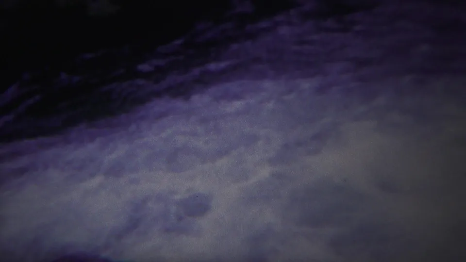 1967 Yellowstone 8mm frame of rough water, pale foam, and dark river shadow with a strong blue-purple cast.