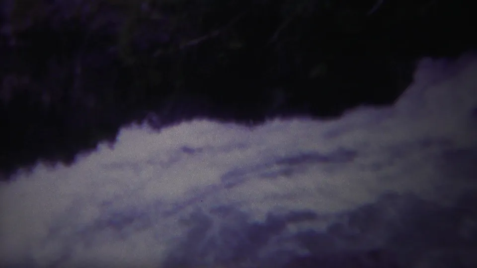 Vintage Yellowstone 8mm view of bright rapids against a dark river edge, with soft focus and color shift.