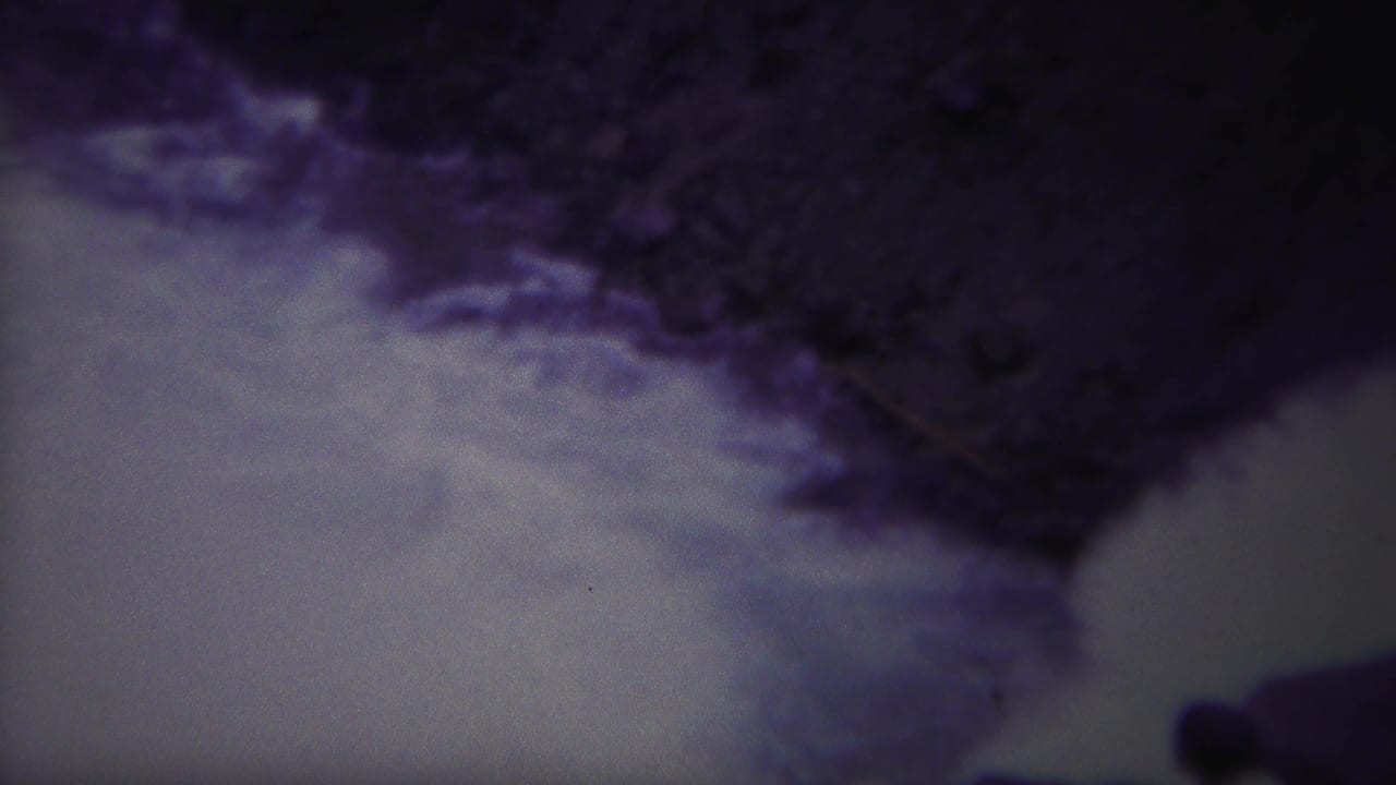A foamy river channel runs below dark rocks, with a small figure near the lower edge.