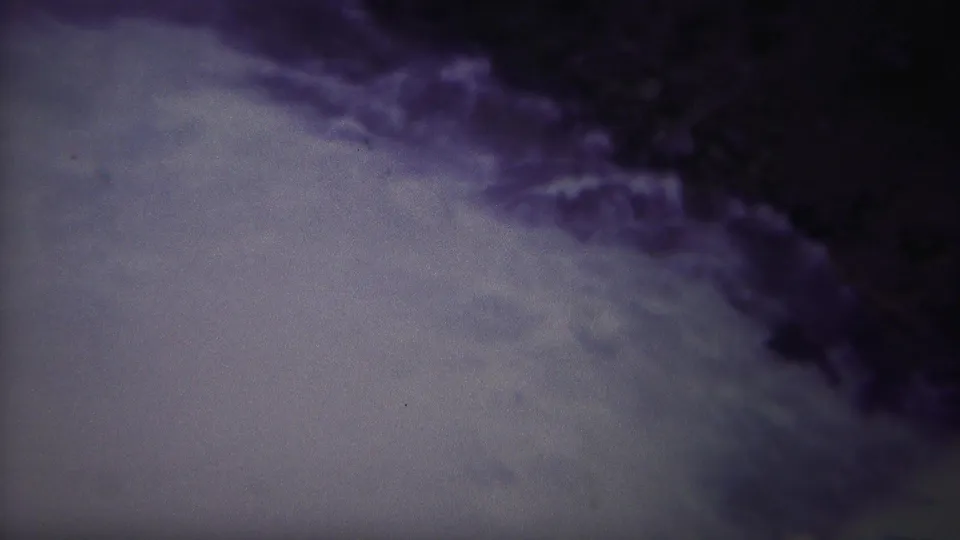 The 1967 Yellowstone home-movie frame looks down at rushing pale water and dark rock, with heavy grain and color fading.