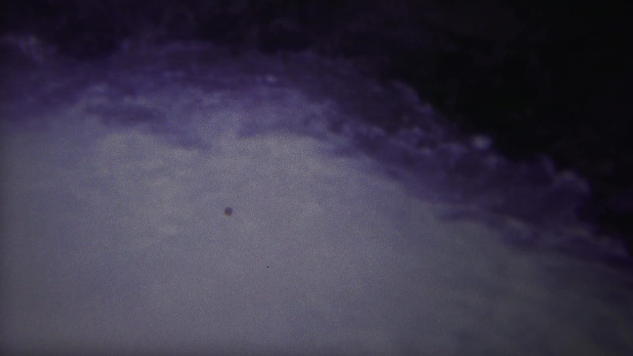 Turbulent pale water beneath a dark purple-blue edge.