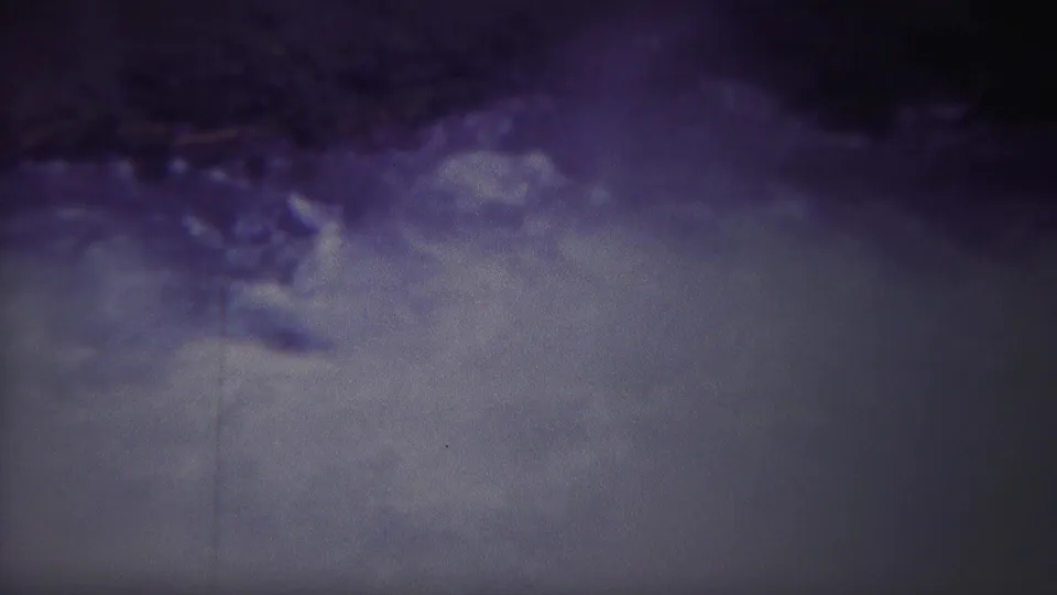 1967 Yellowstone frame showing swirling river current and foam, with the shoreline or rocks partially visible along the upper edge.