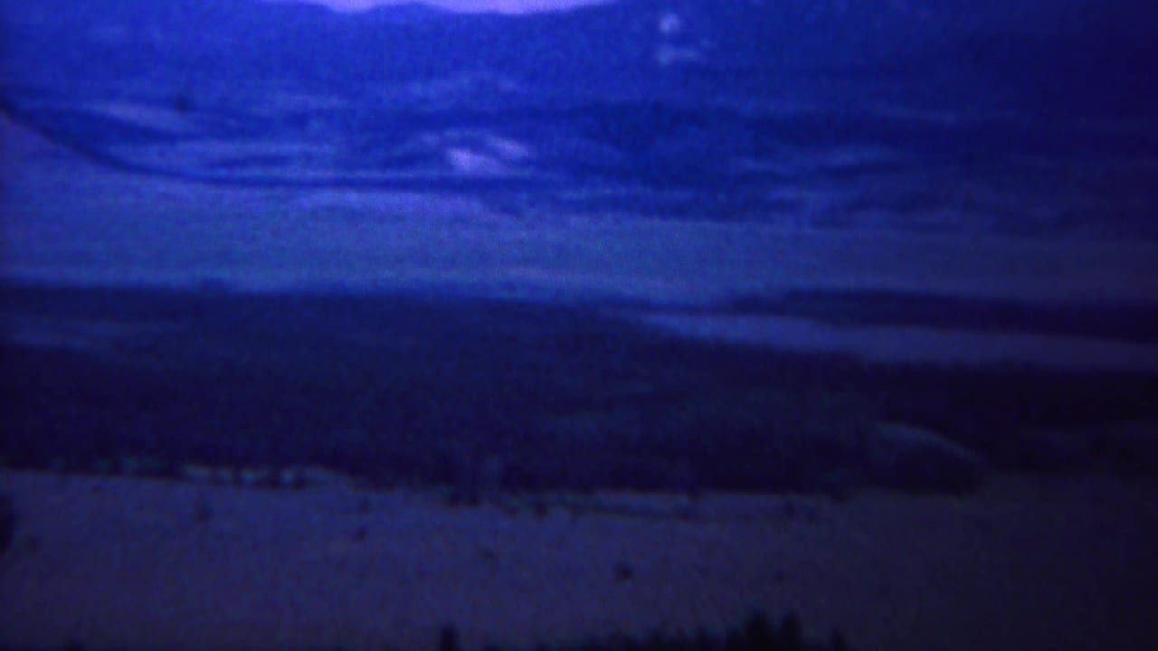 1967 8mm home-movie frame of a likely Yellowstone mountain and valley view with heavy blue color cast.