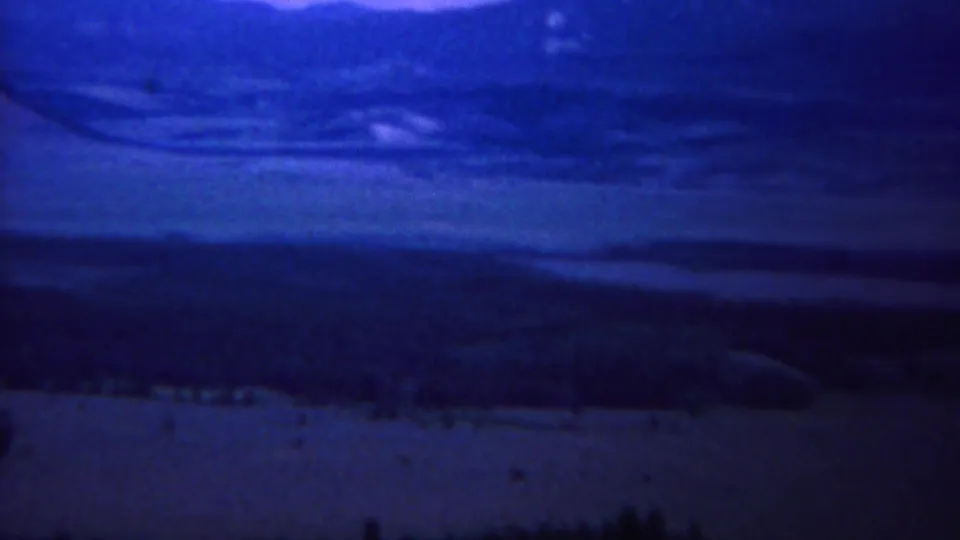 1967 8mm home-movie frame of a likely Yellowstone mountain and valley view with heavy blue color cast.