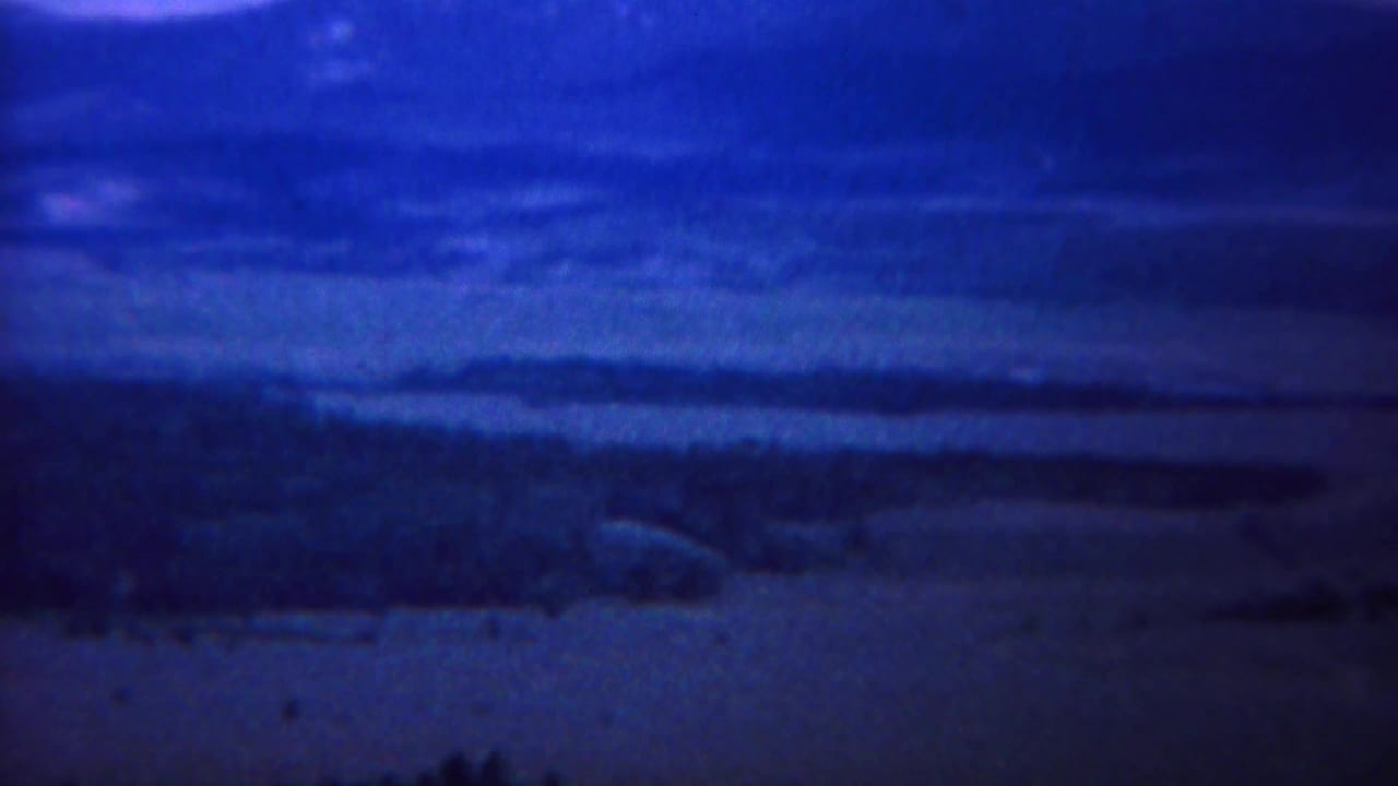 Distant mountains and valley bands in a dark blue scenic panorama.