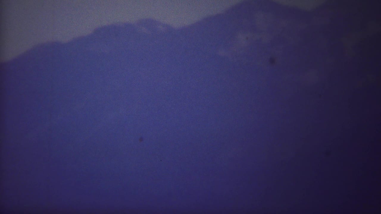 Dark mountain silhouette fading into blue haze.
