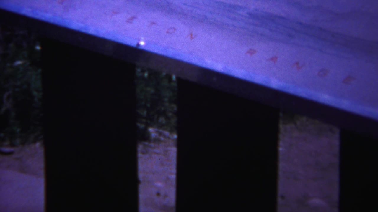 Close view of a pale wooden surface above dark openings and vertical supports.