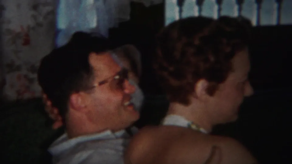 The man remains behind the woman, smiling as she turns slightly away in the 1951 Westville living-room scene.
