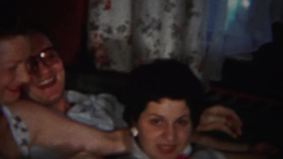 A second woman is visible beside the embracing couple in the dim 1951 Westville interior, suggesting a relaxed family gathering.