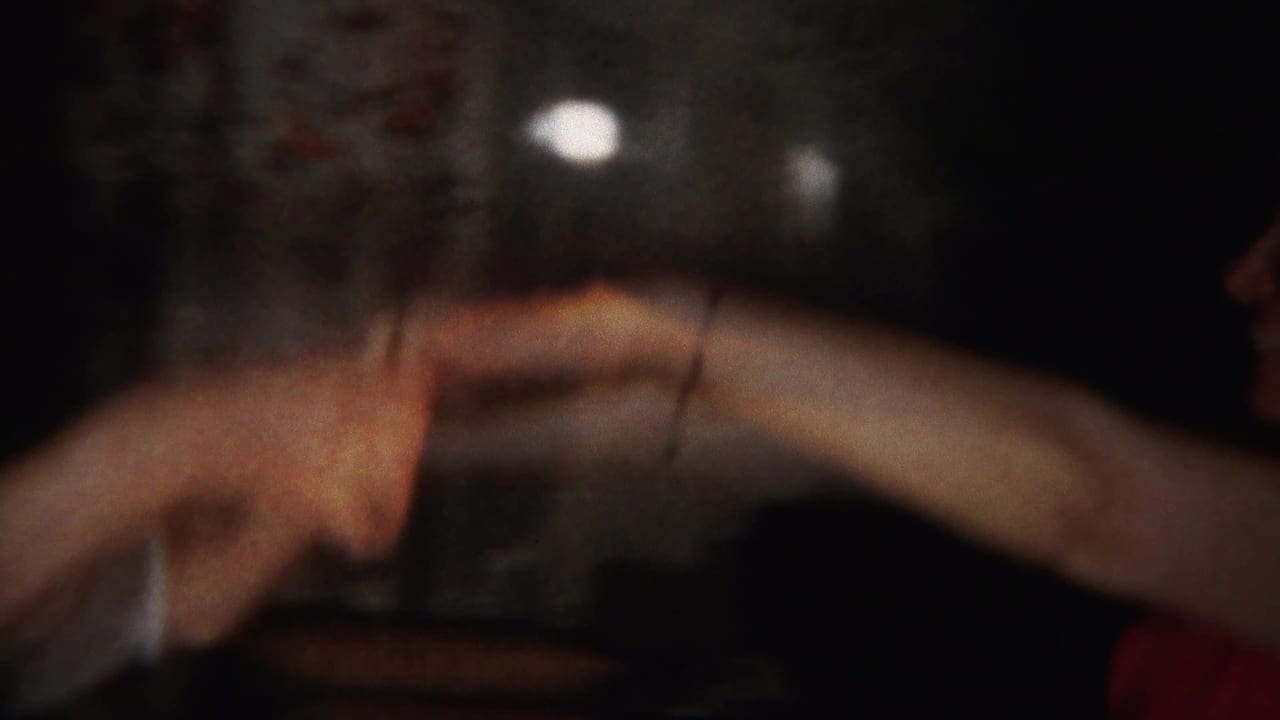 Two young women in formal dresses hold hands while dancing in a dim Westville, New Jersey home-movie scene from 1951.