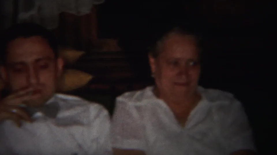 1951 Westville interior frame with a man holding a cigarette and an older woman seated nearby on a couch.