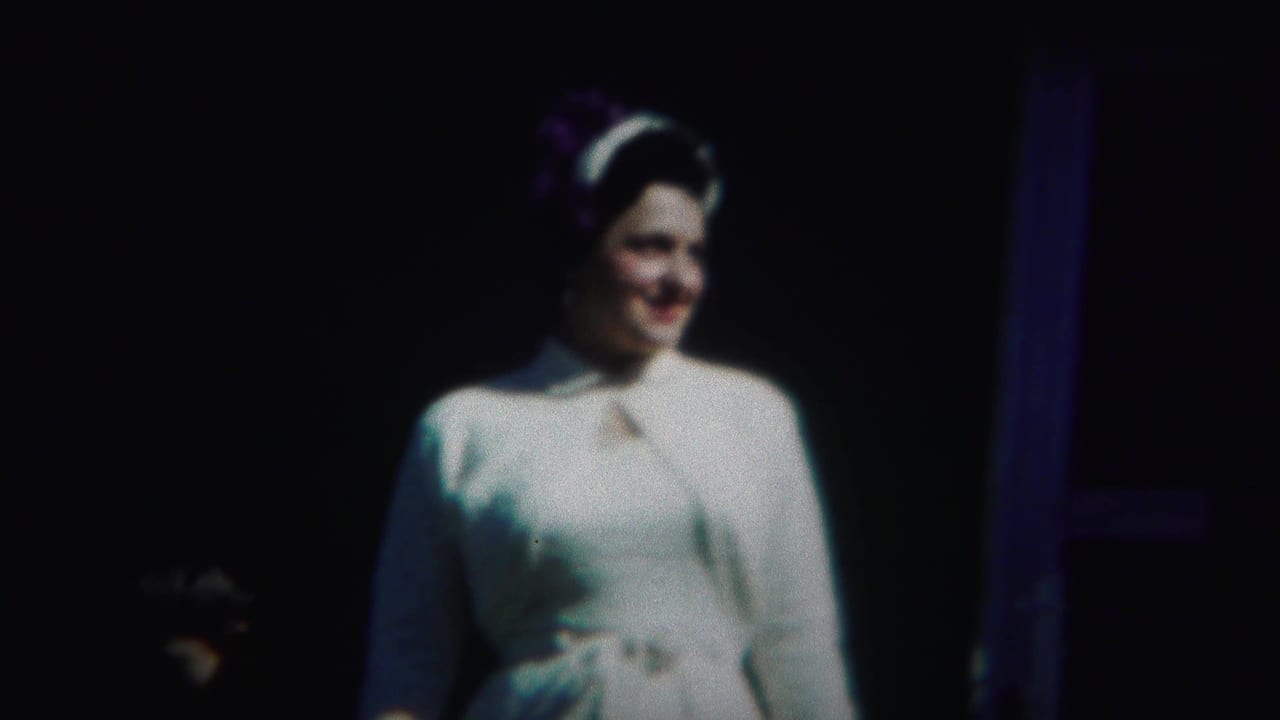 The woman in white formal attire appears in soft 8mm focus, turned slightly beside a dark doorway or post in the 1951 Westville footage.