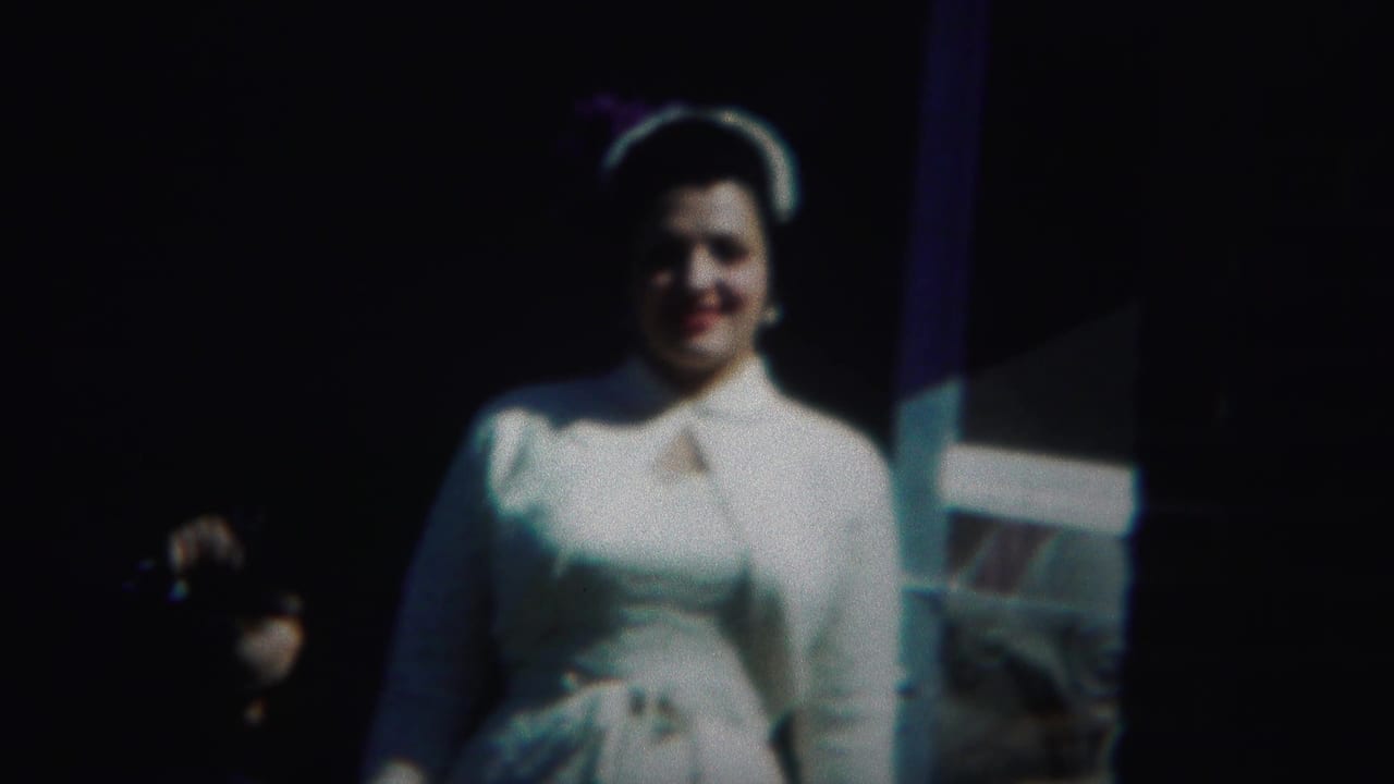 In 1951 Westville home-movie footage, a brunette woman in a white dress and matching hat faces the camera and smiles.