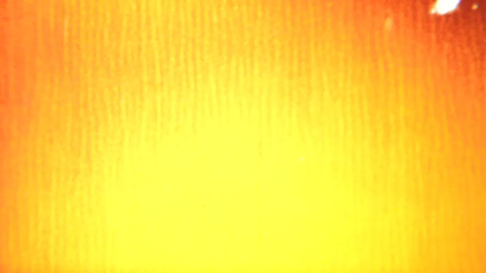 Bright yellow-orange exposure flare on the 1951 Westville 8mm reel, with visible vertical texture and warm color shift.