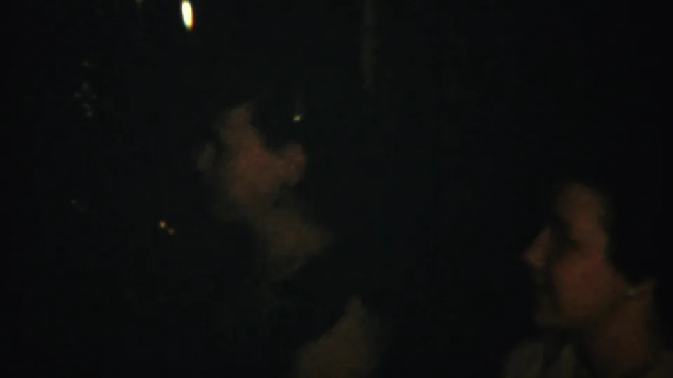 Westville, New Jersey 1951 home-movie frame showing several adults in a dark interior gathered closely together.